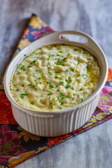 cream cheese mashed potatoes topped with fresh chives in a serving dish