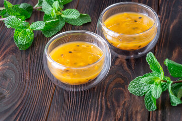 Passion Fruit Pulp in Glass Bowls on Rustic Wood