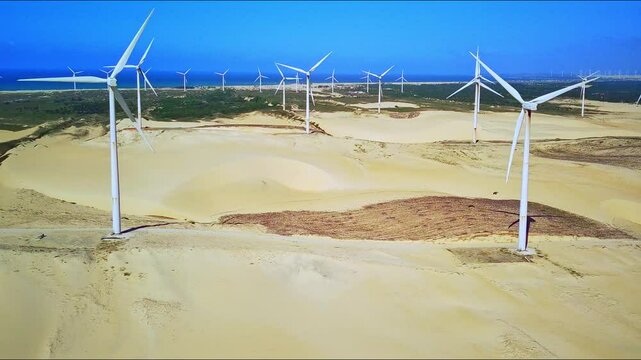 Wind power, dunes and the sea in the background make for a perfect setting. Clean energy that helps the environment.