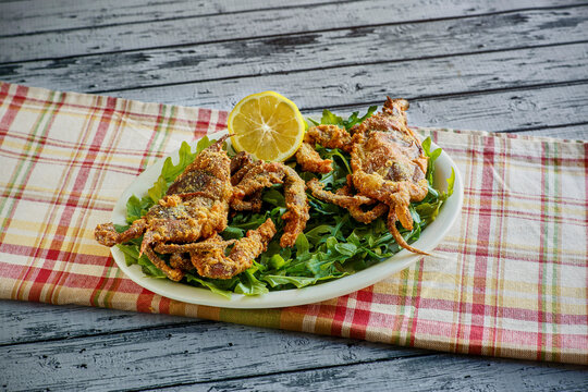 crispy fried soft shell crabs served with fresh lemon on white platter