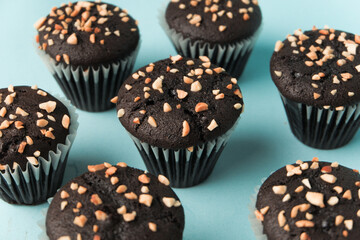top view and detail Chocolate muffin or cupcake with egg and cake ingredients on blue background. Home baking concept