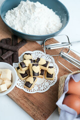 Homemade chocolate cookies on wooden plate with all ingredients, photographed from the top view