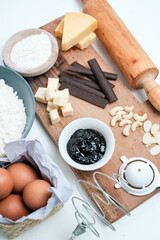 Baking ingredients for chocolate cake muffins or cookies lying ready on wooden kitchen tray. Mise en place, white background, measured ingredients.
