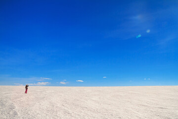 Arctic winter landscape, panorama, banner - view of a snowy desert field and girl looking at the sky in the rays of the winter sun