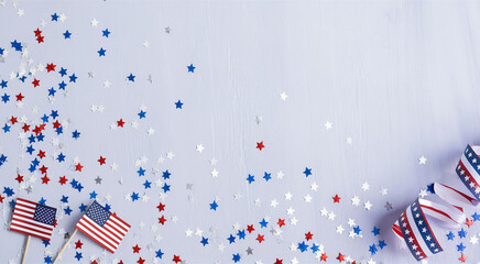 Obraz premium Patriotic American scene, wooden table background, scattered red white and blue confetti, small American flags, striped party hats, festive atmosphere, 4th of July celebration, Independence Day decor,