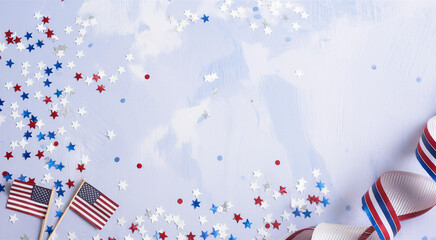 Obraz premium Patriotic American scene, wooden table background, scattered red white and blue confetti, small American flags, striped party hats, festive atmosphere, 4th of July celebration, Independence Day decor,