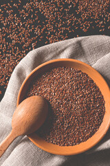 Cereals. Flax seeds in a wooden plate with a wooden spoon. Top view