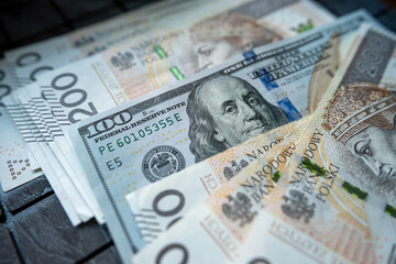 200 pln Polish zloty vs 100 US dollar banknotes as exchange rates. Spilled money.