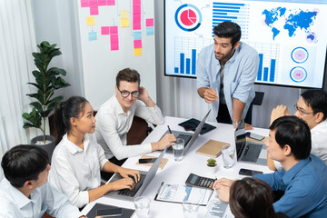 Analyst team utilizing BI Fintech to analyze financial data at table in meeting room. Businesspeople analyzing BI dashboard power for business insight and strategic marketing planning. Prudent