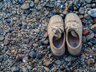 Shoes on pebbles near sea shore