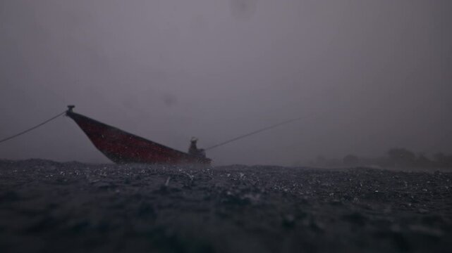 Local fisherman fishing inder rain in small boat. Traditional vessel, arabic man in sea. Sail in open ocean, bad weather. Tranquil cinematic shot. Bali indonesia vibe. Gloomy seascape. Transportation