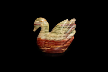 Brown marble decoration in shape of a swan, isolated on black background