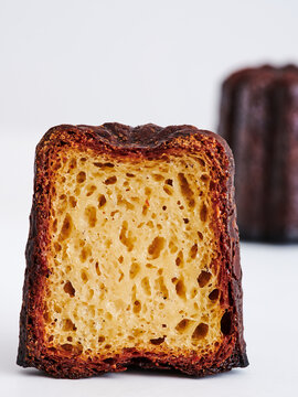 A freshly cut pastry reveals its fluffy, light interior contrasted with a beautifully caramelized exterior. The details highlight the intricate texture and appealing color