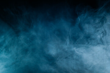 Abstract swirling blue smoke on a dark background, creating a mysterious and ethereal atmosphere. Perfect for artistic, moody, or creative designs.