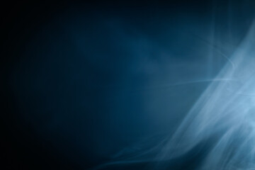 Abstract swirling blue smoke on a dark background, creating a mysterious and ethereal atmosphere. Perfect for artistic, moody, or creative designs.