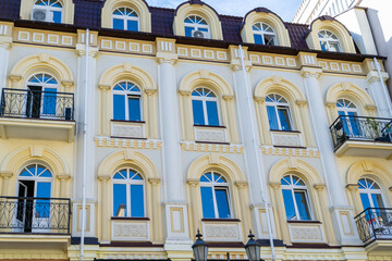 Fototapeta premium Facade of yellow house. Residential buildings. Bright windows. Balcony modern architecture. Exterior