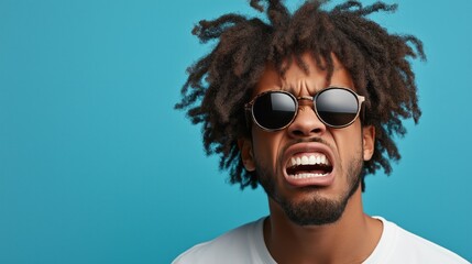 Expressive man with afro hairstyle demonstrating frustration in casual fashion against blue background for portrait designs