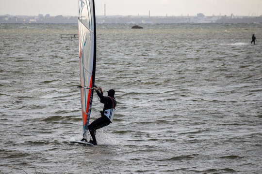
A man riding a windsurfer on the water.
