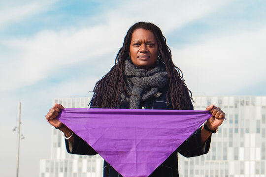 African american woman with purple kerchief on 8m women's right march