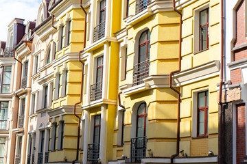 Facade of Colorful yellow Houses Buildings. Bright windows architecture.