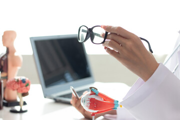 Surgeon with human eye model and explains in modern clinic treatment