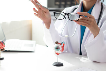 Surgeon with human eye model and explains in modern clinic treatment
