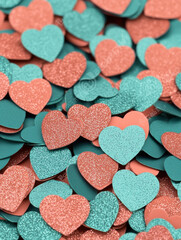 Fototapeta premium Glittery heart shaped confetti in teal and coral colors, creating vibrant design