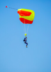 Skydiving. Flying parachutists against the background of the blue sky and mountains. Extreme sport and entertainment.