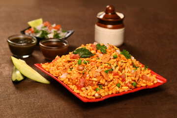 bhel in red flatter with red& green chatny brown backround ,tomato& onions with rw mango 