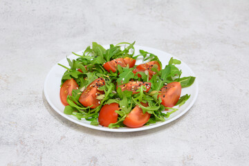 some greenery with seeds and slices of tomato on the plate 