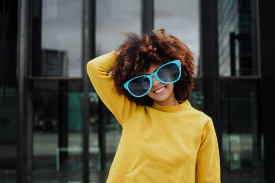 Latin afro girl smiling with funny glasses. Vibrant colours