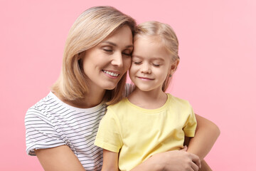 Cute little girl with her mom on pink background. Happy Mother's Day