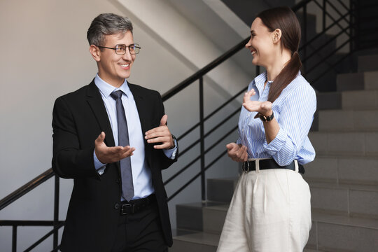 Coworkers talking while going down stairs in office