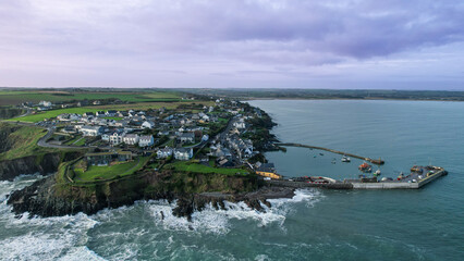 A stunning aerial view of Ballycotton village, with its rugged cliffs, serene harbor, and iconic lighthouse from the sea