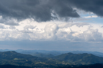 Obraz premium Mountains ranges in the Carpathians. Hills, forest and meadows. Green valley. Dark sky clouds