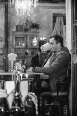 young man in cafe drinking from cup