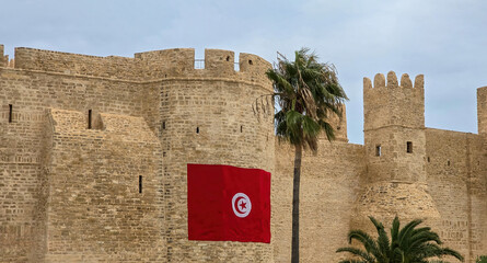 Ribat of Monastir in Tunisia with Tunisian flag and palm tree..