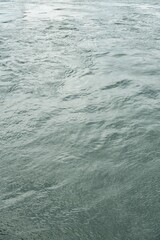 Abstract azure water surface with mild waves, vertical