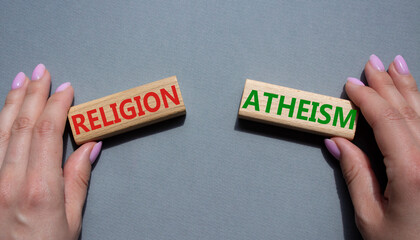 Religion or Atheism symbol. Concept word Religion or Atheism on wooden blocks. Businessman hand. Beautiful grey background. Business and Religion or Atheism concept. Copy space