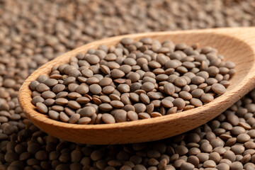 Lentils picked up by a wooden spoon
