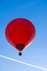 Flying red hot air balloon in the blue sky