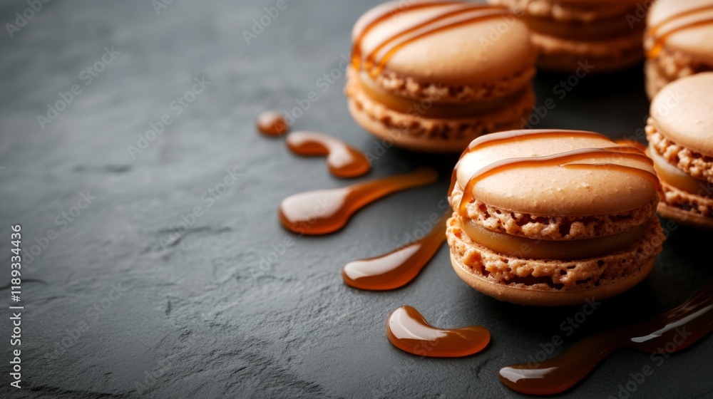 Poster A close-up of caramel-flavored macarons with a glossy caramel drizzle on top, arranged neatly on a dark stone surface with caramel sauce swirled around.