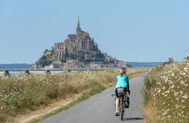 Solo female traveler cycling around mount San Michele.
