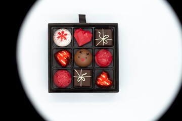 Box with handmade chocolates on a white and black background, Valentine's Day.