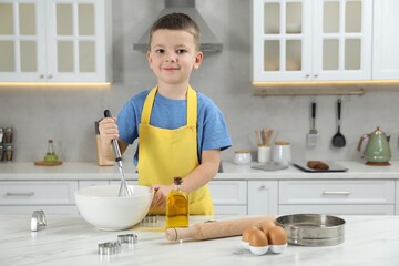 Little helper. Cute boy making dough for cookies in kitchen at home