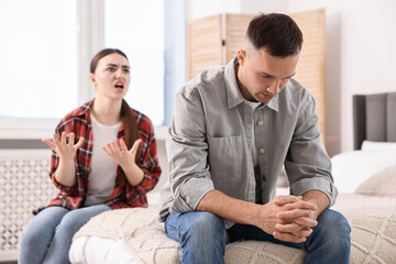 Husband ignoring his emotional wife at home, selective focus