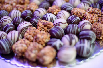 Round small cakes with white and dark chocolate as well as finely chopped hazelnuts on a pile