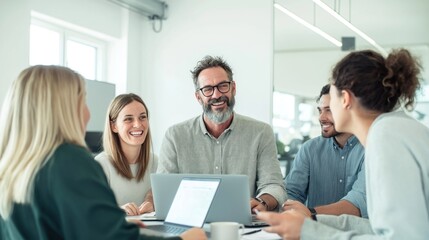Business team gathers in modern office for marketing strategy planning session. Colleagues discuss ideas, brainstorm solutions together. Project manager uses laptop explaining ideas to team. Happy