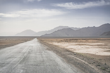 Asphalt road of the Pamir Highway in the valley of the Tien Shan Mountains in Tajikistan in the...