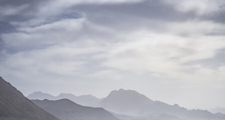 Minimalist silhouette of a mountain range in the highlands of the Tien Shan in the Pamirs in Tajikistan, panoramic landscape for the background with rocky mountains
